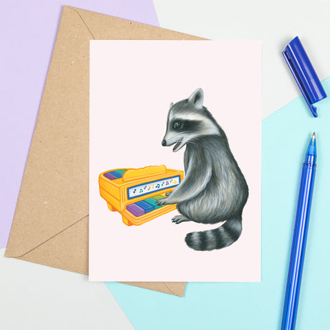 Baby Raccoon playing on vintage toy piano - Greeting Card